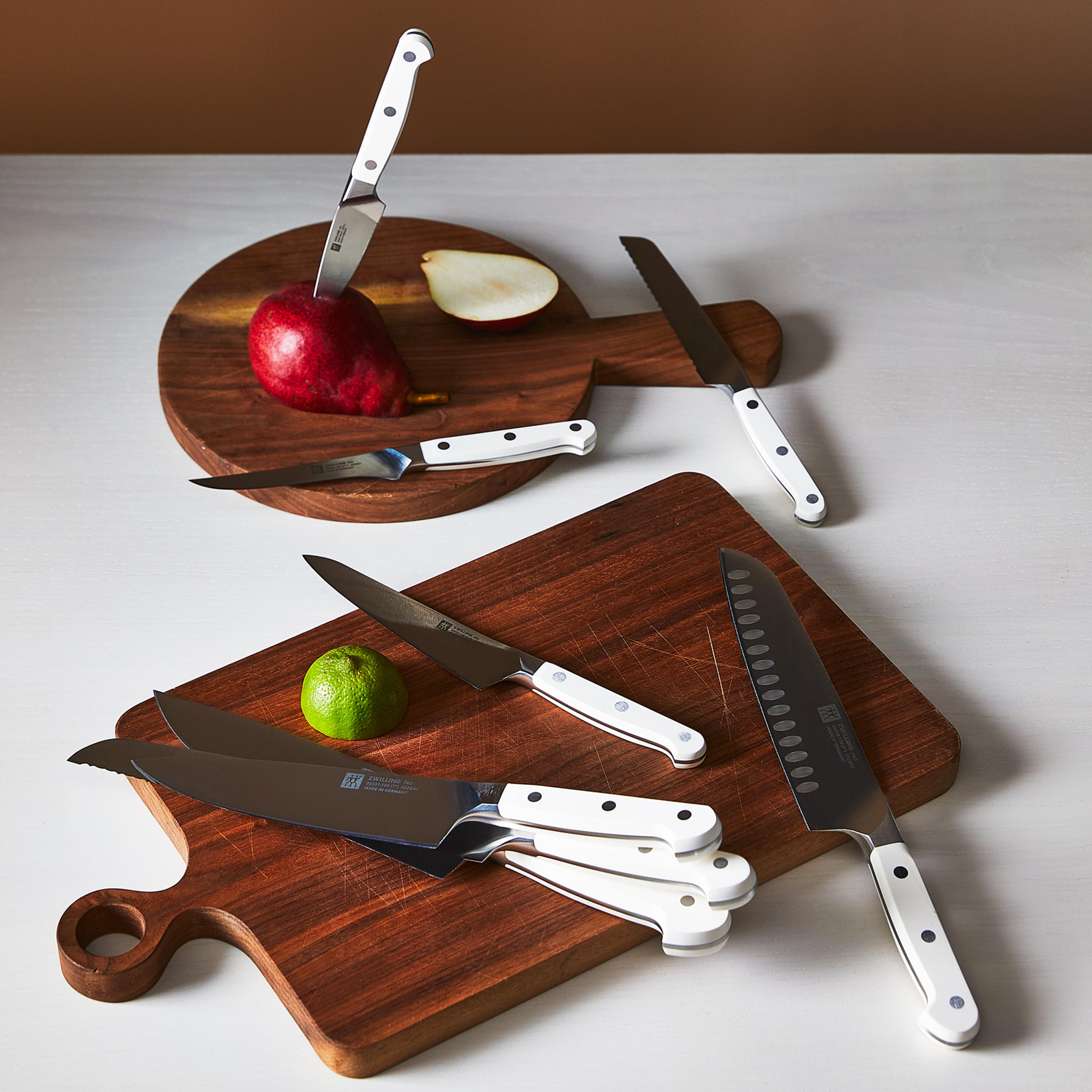 white kitchen knives on a board