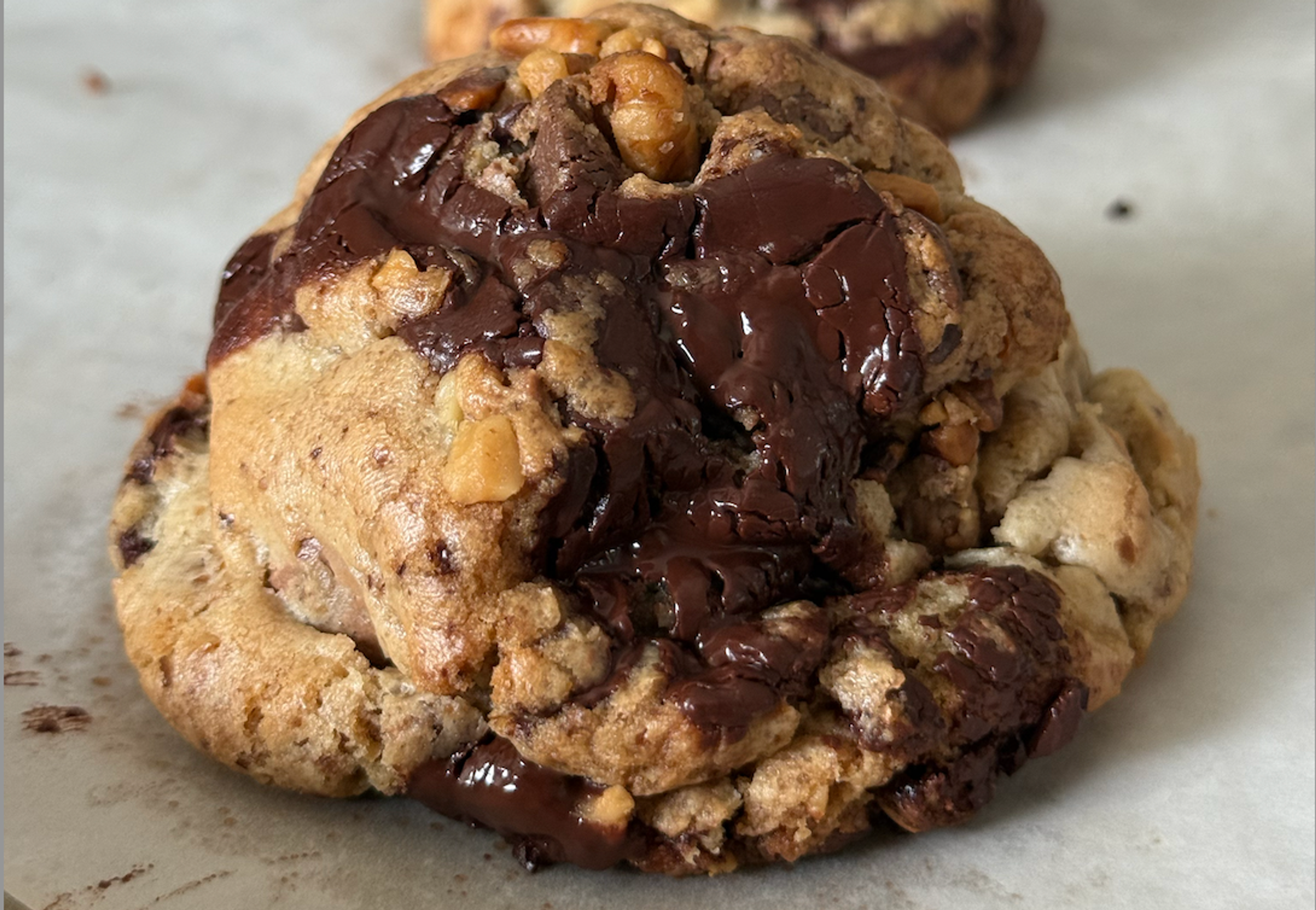Thick cookie on a white baking sheet.